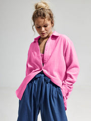 Textured cotton overshirt in hot pink with relaxed fit and button front, styled open over a bralette.