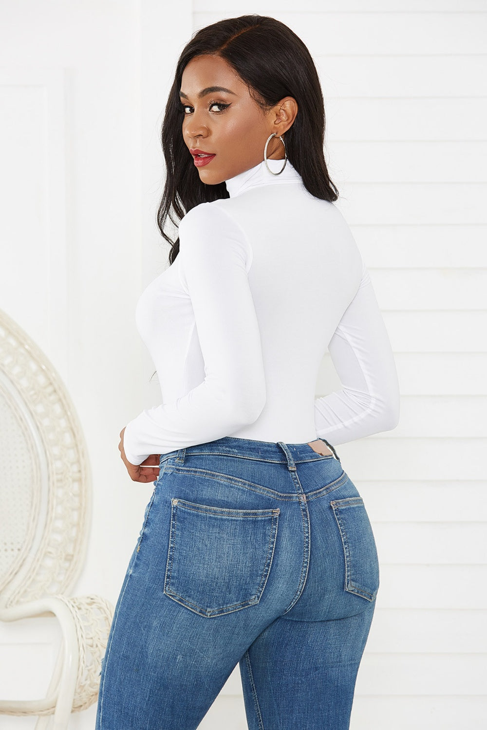 White long sleeve turtleneck thong bodysuit with a thong back.