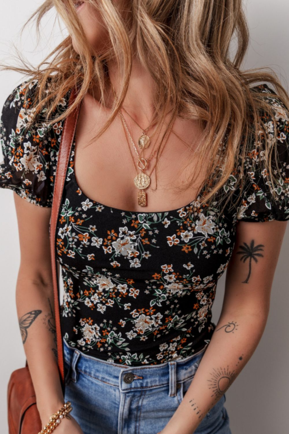 Black floral puff sleeve bodysuit with a square neckline.