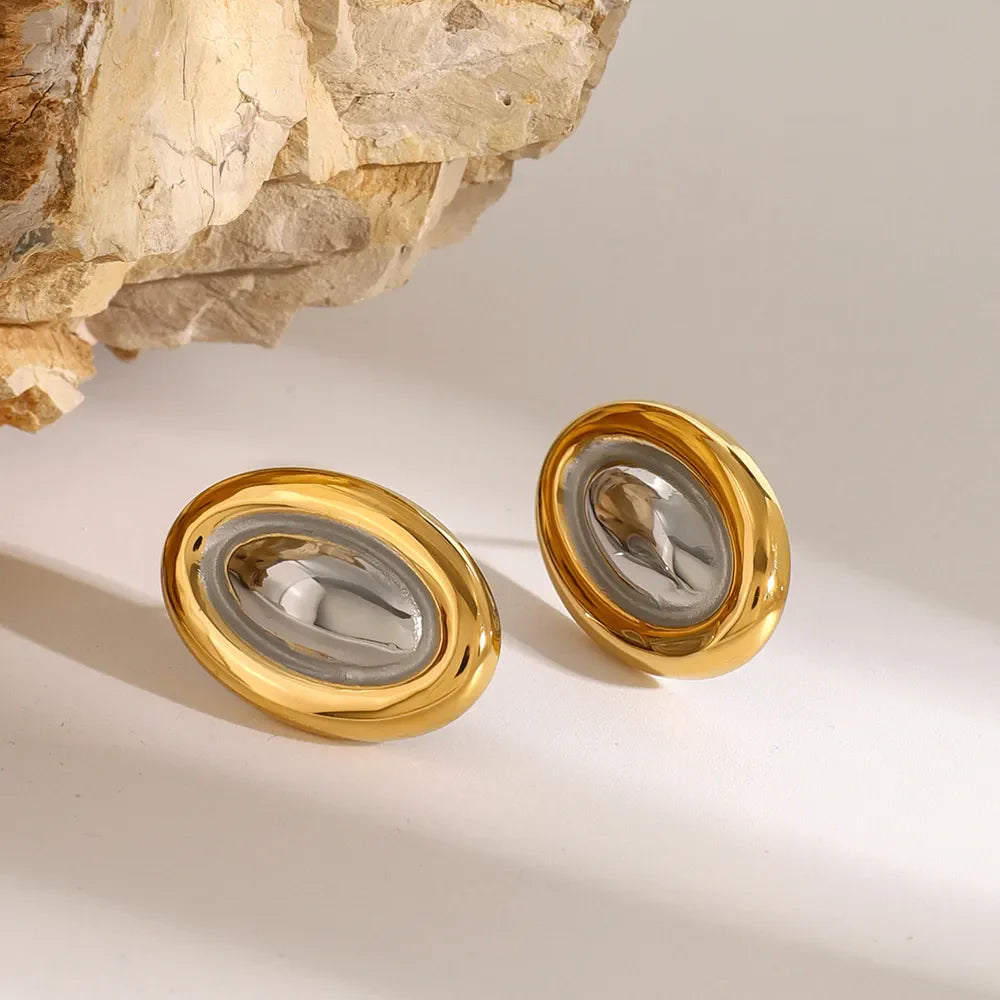 Gold two-tone oval statement earrings with a polished finish and textured center.