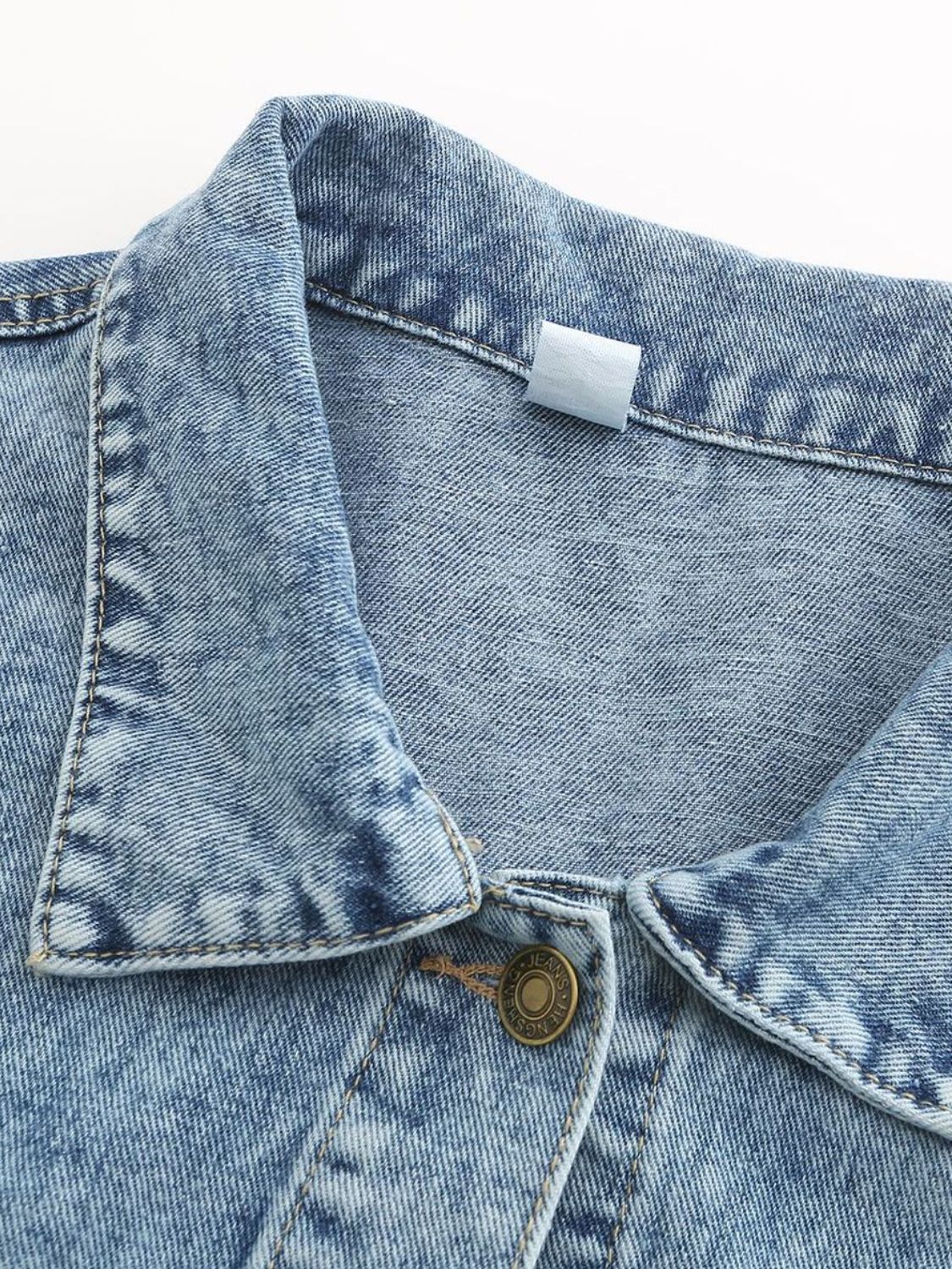 Light wash oversized denim jacket with button closure and collar detail.