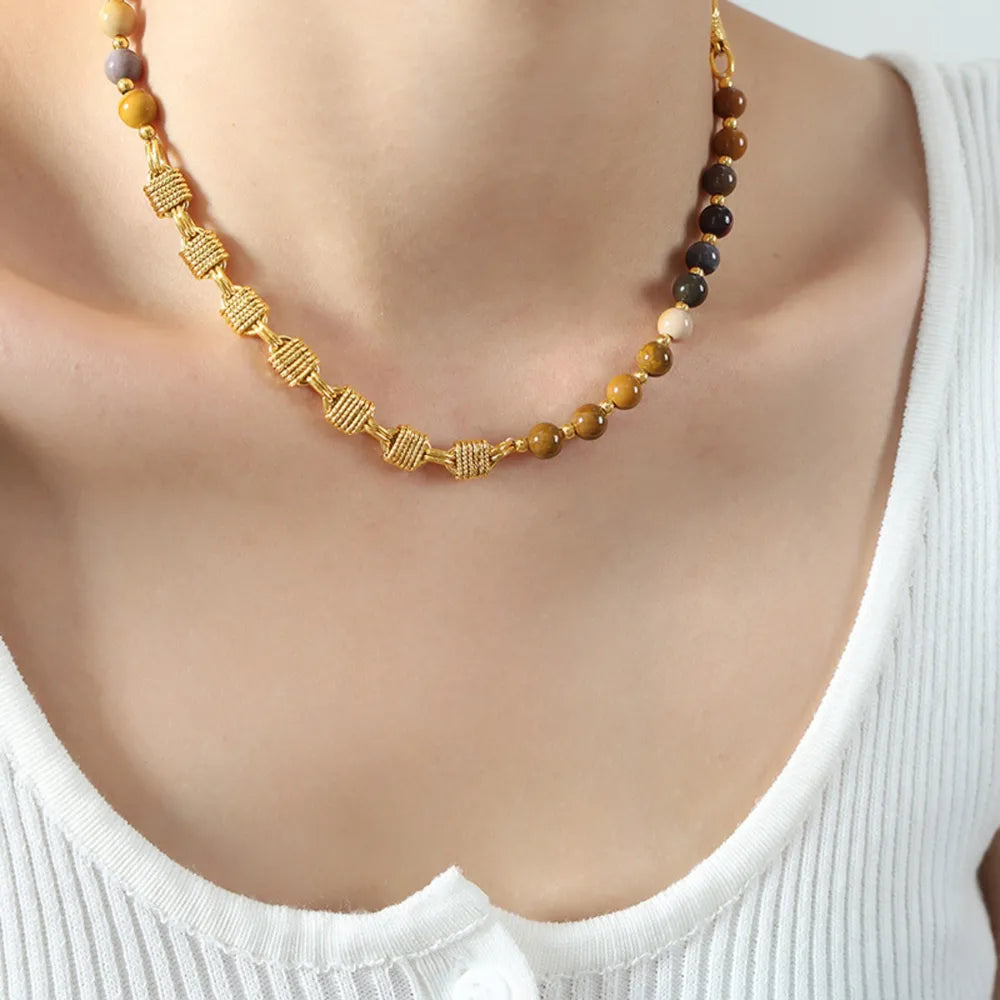 Gilded bead and chain statement necklace with gold woven details and multi-colored beads.