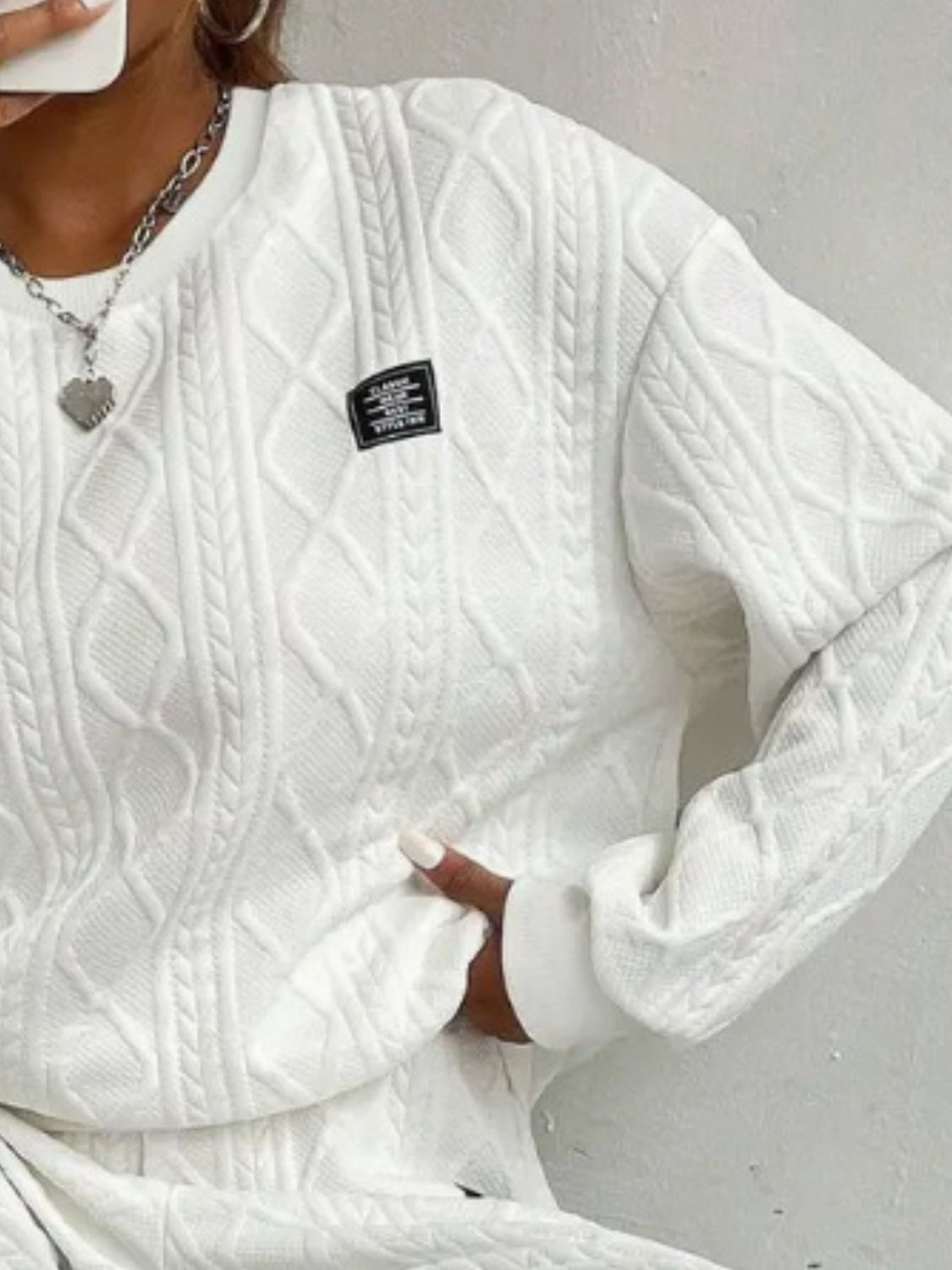 White cable knit loungewear set with textured diamond pattern and crew neck.