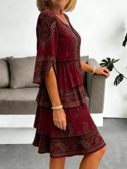 Burgundy paisley print mini dress with tiered ruffles and split sleeves.