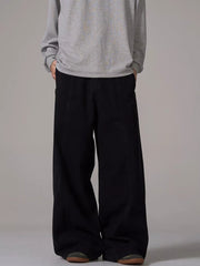 Black wide-leg sweatpants with pockets and seam detail, worn by a man.