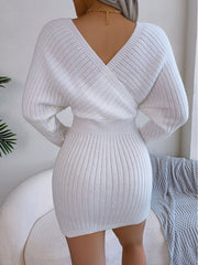 White acrylic wrap knit bodycon mini dress with V-neck and long sleeves.