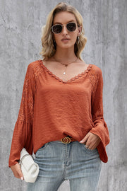 Orange-red blouse with lace sleeves and scallop trim, v-neck, long bell sleeves.