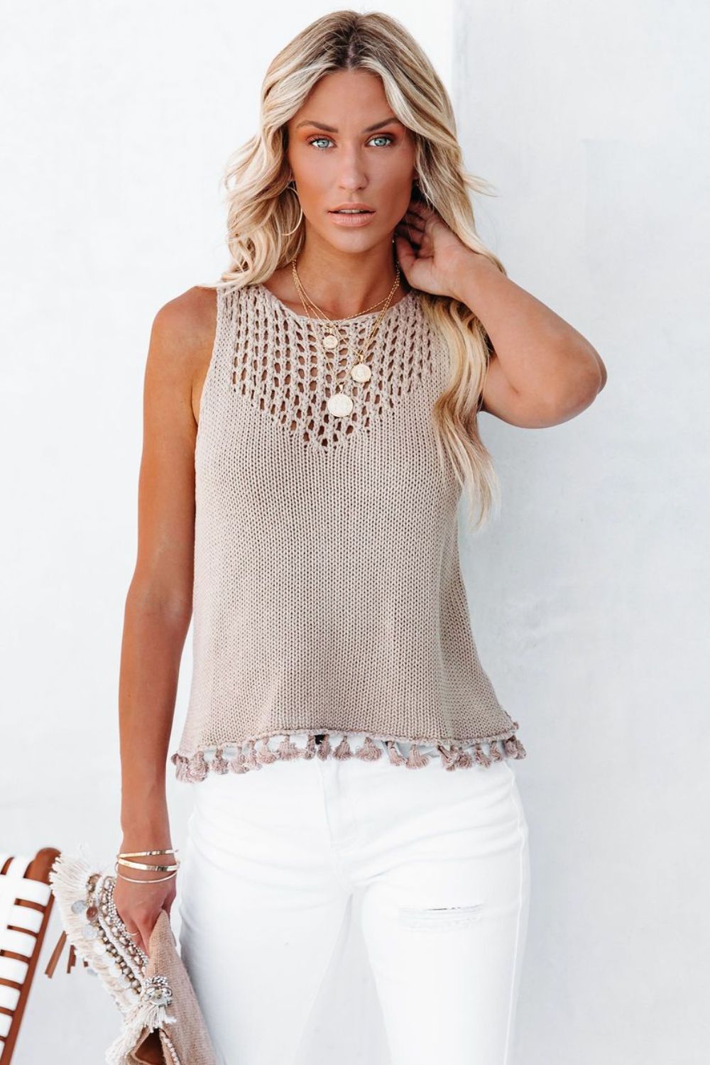 Tan openwork knit tank top with crochet neckline and tassel trim.