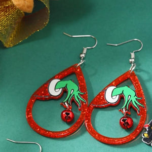Red glitter teardrop acrylic earrings with Grinch hands holding jingle bells.