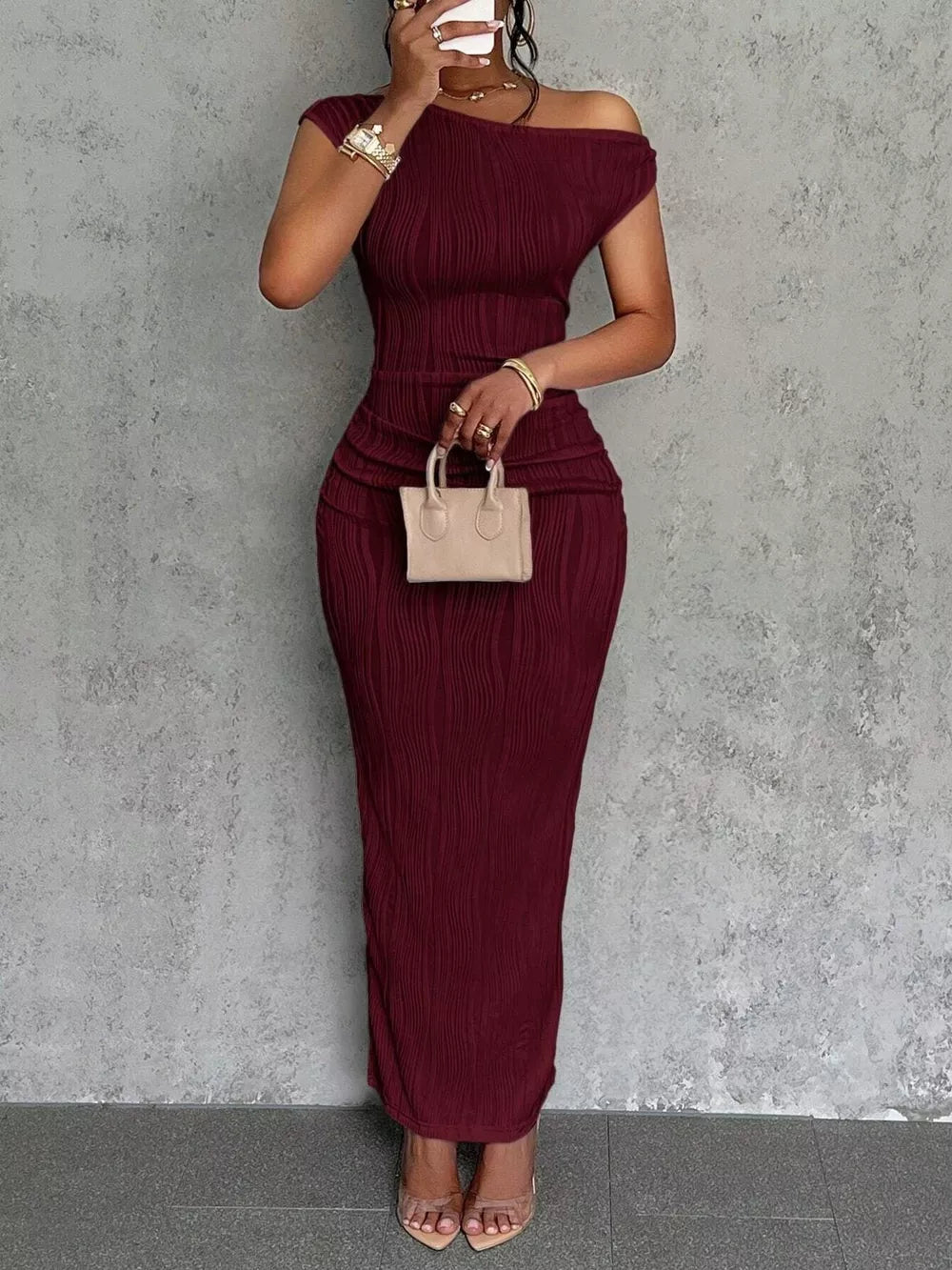 Wine red textured one-shoulder maxi dress with ruched detail and asymmetrical neckline.