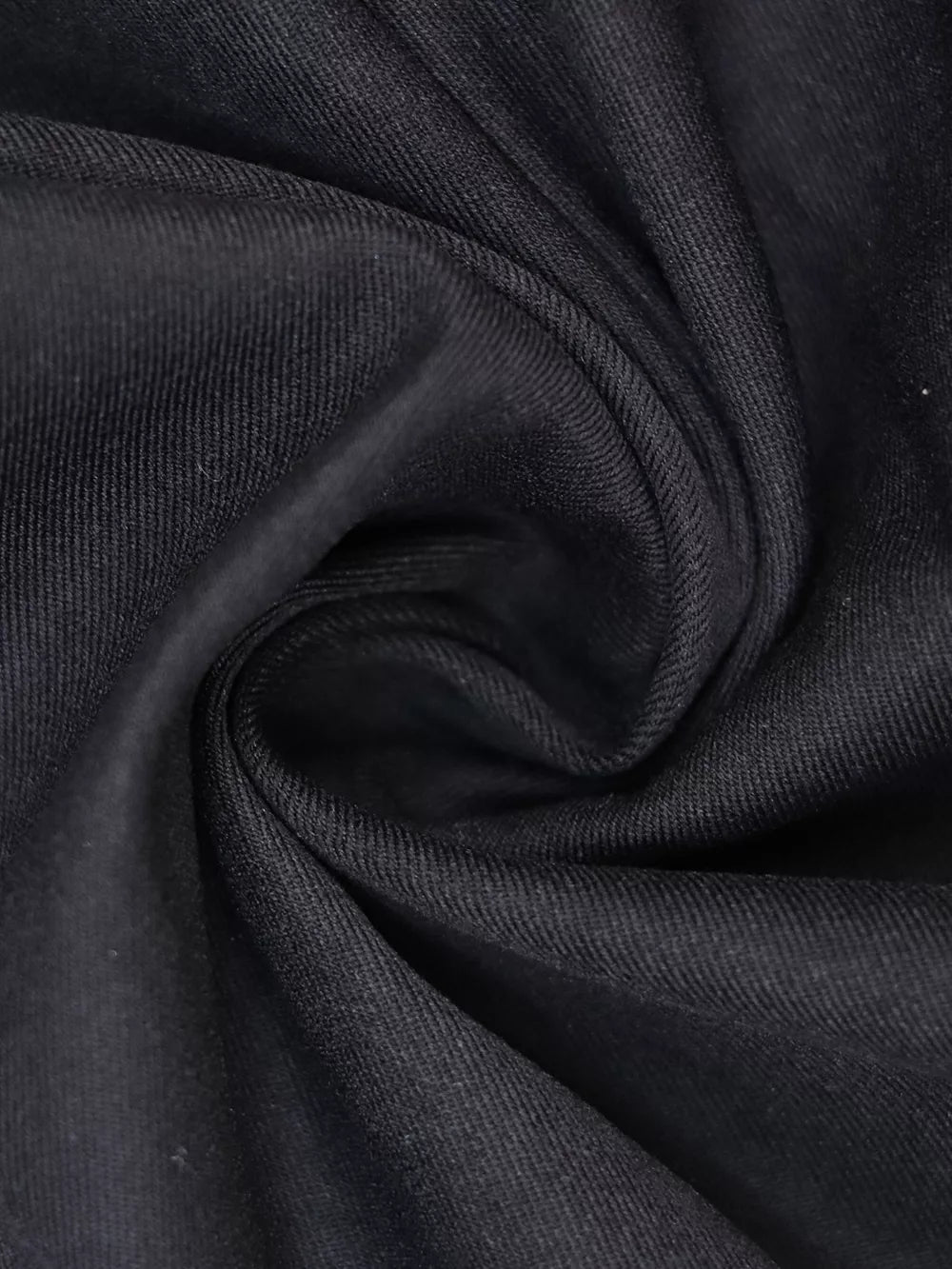 Black midi dress fabric detail with visible texture and subtle sheen.