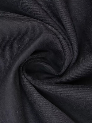 Black midi dress fabric detail with visible texture and subtle sheen.