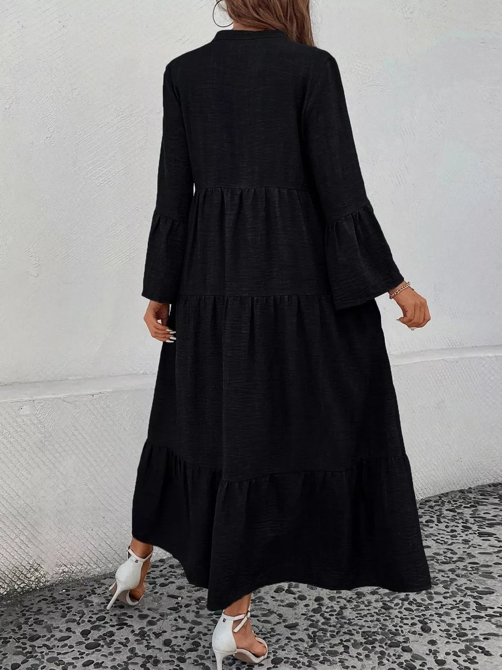 Black tiered ruffle hem dress with long bell sleeves and a v-neck.