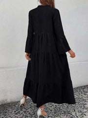 Black tiered ruffle hem dress with long bell sleeves and a v-neck.