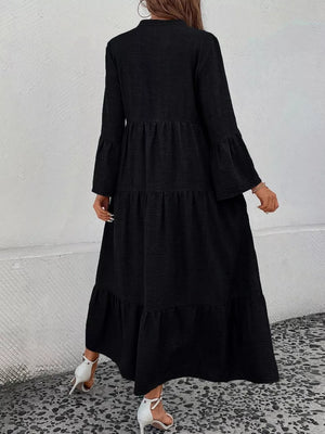 Black tiered ruffle hem dress with long bell sleeves and a v-neck.