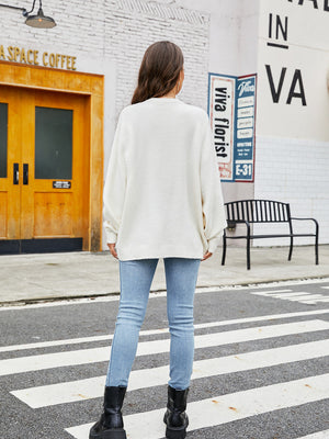 White crewneck knit sweater with balloon sleeves and textured detail.
