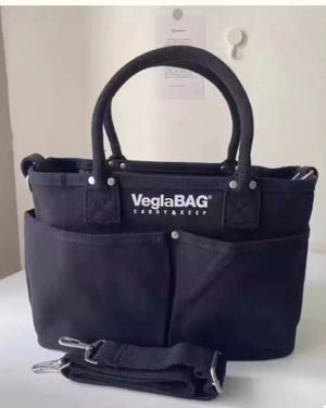 Black canvas shopper bag with multiple exterior pockets and detachable strap.