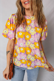 Puff sleeve blouse with ruffle trim and a colorful floral print.