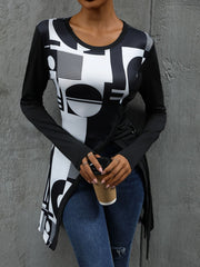 Black tunic with asymmetric geometric print, long sleeves, and a draped hem.