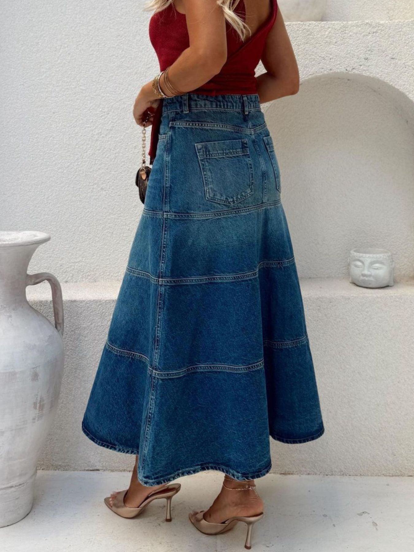 Plus high-waisted denim A-line skirt in dusty blue with tiered panels and back pockets.
