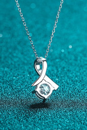 Silver ribbon pendant necklace with a solitaire diamond accent.