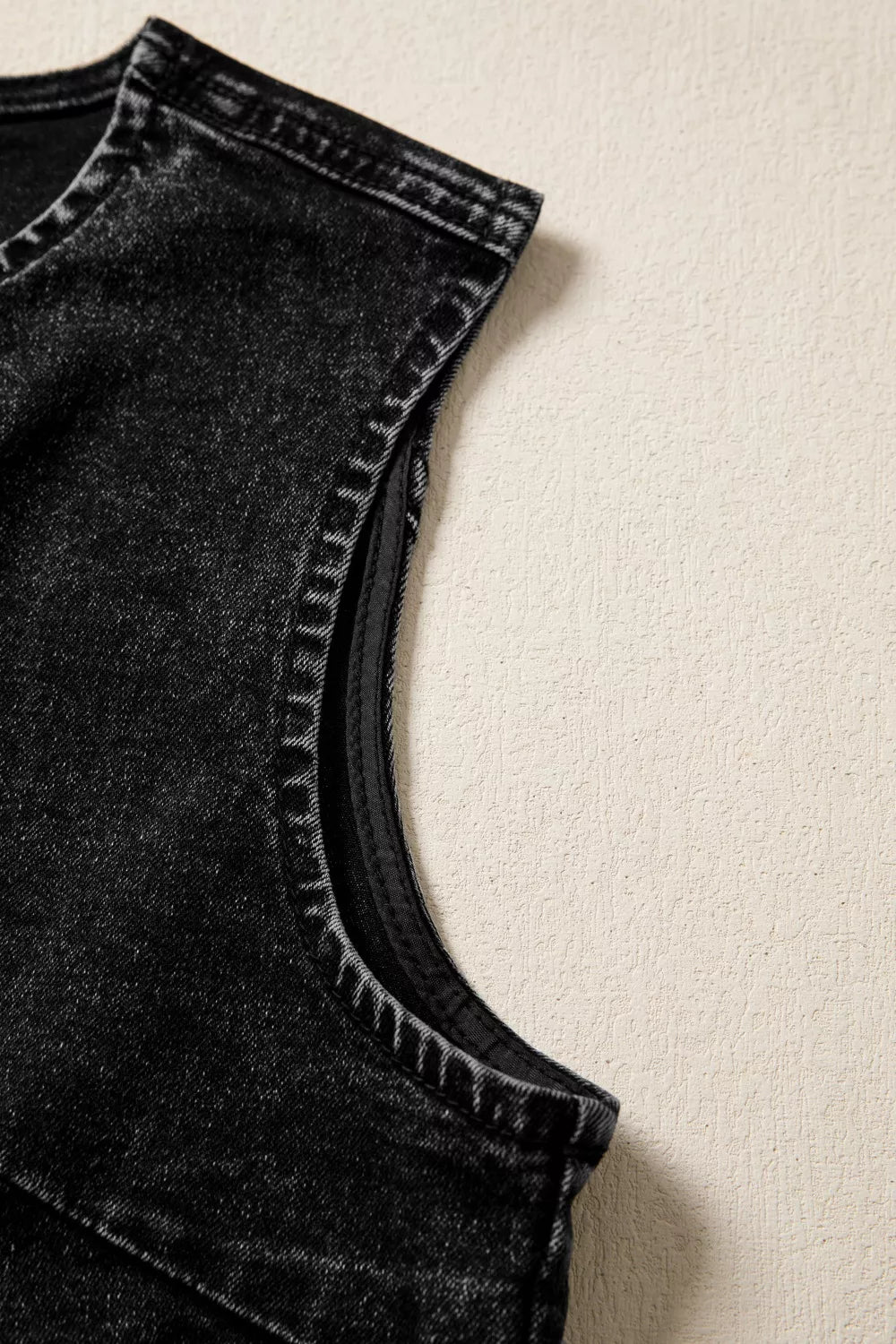 Black denim vest with vintage wash and visible stitching detail on the armhole.