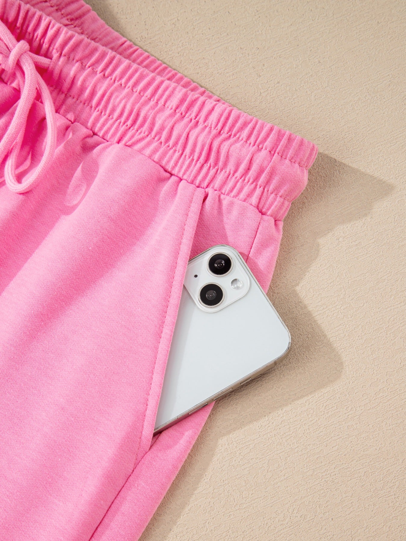 Pink cotton drawstring bikini bottoms with elastic waistband and pocket detail.