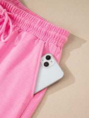 Pink cotton drawstring bikini bottoms with elastic waistband and pocket detail.