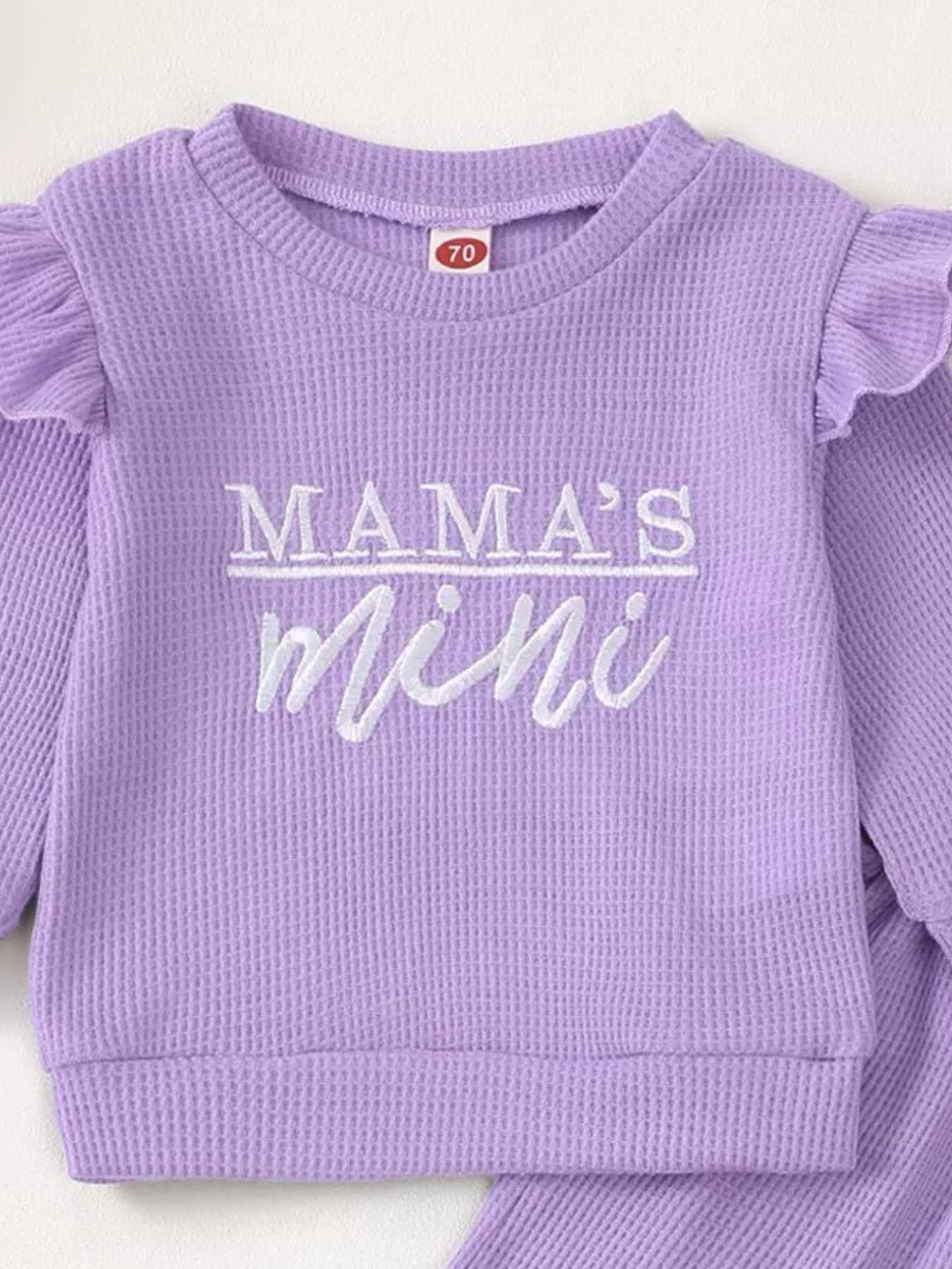 Purple waffle knit toddler top with ruffled sleeves and "Mama's Mini" embroidery.