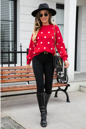 Red polka dot knit sweater with balloon sleeves and round neckline.