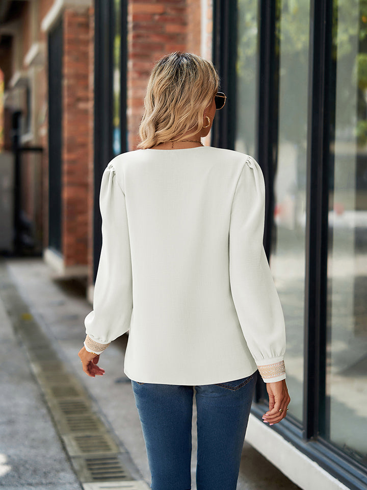 White blouson sleeve top with embroidered trim cuffs and puff sleeves.