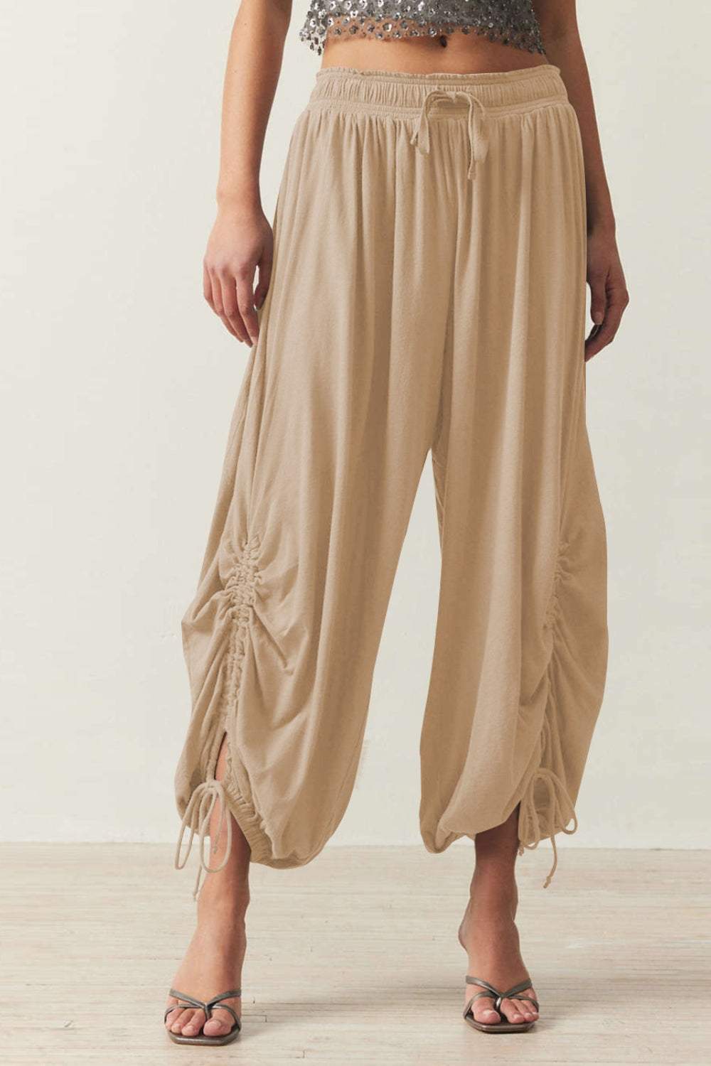 Tan gathered ankle-tie balloon trousers with drawstring waist and ruched side detail.