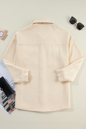 Beige corduroy oversized utility jacket with long sleeves and collar.
