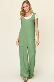 Light green ribbed knit tie-strap jumpsuit with wide legs and front pockets.