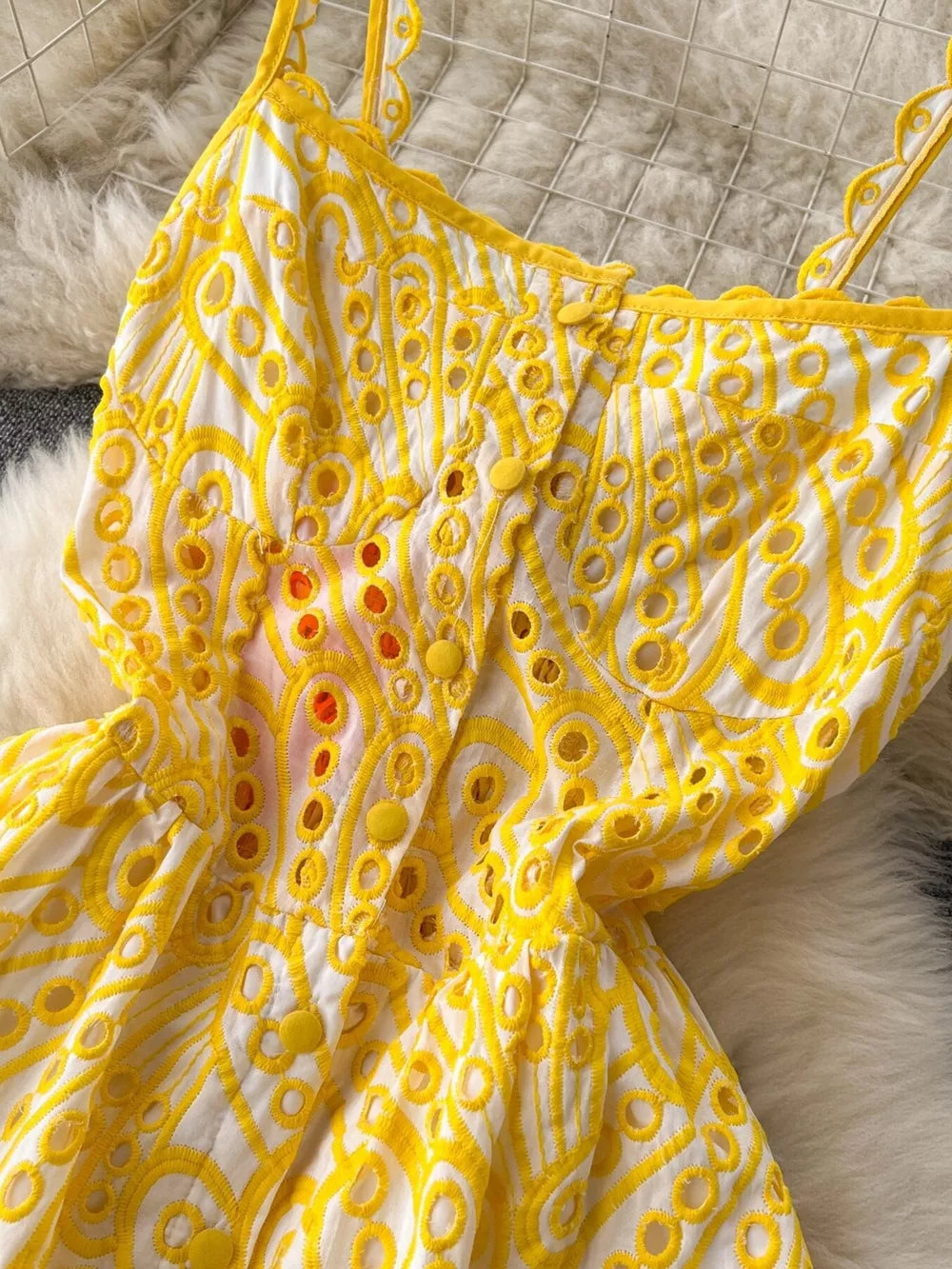 Yellow lace-embroidered cami dress with eyelet detail and scalloped straps.