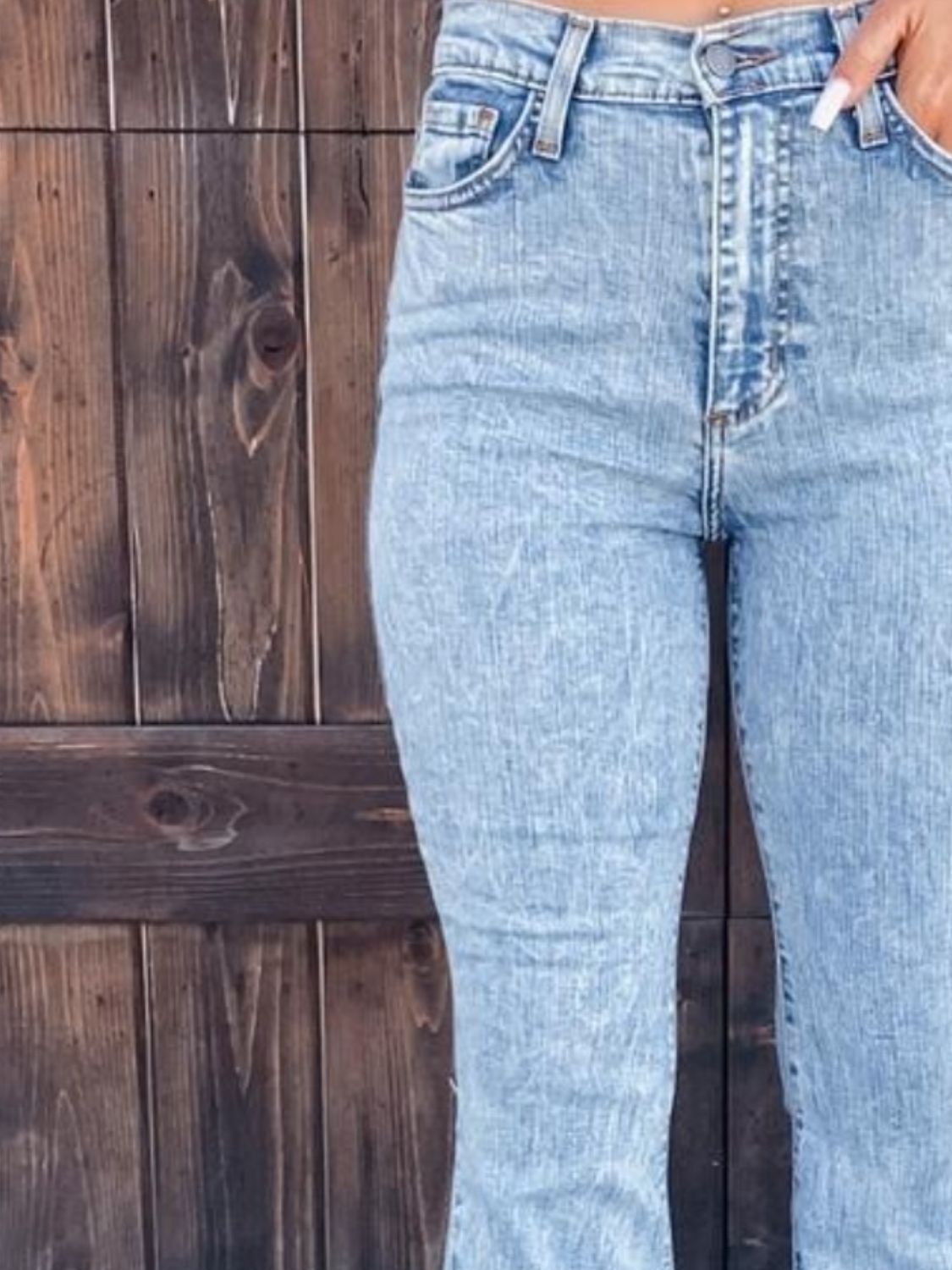 Light blue acid wash flare jeans with button fly and 70s style.