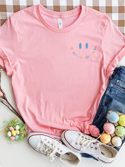 Pink t-shirt with a colorful smiley face graphic and text Be Kind To Your Mind.