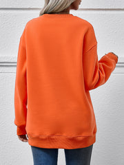 Orange crewneck sweatshirt with ribbed cuffs and hem, relaxed fit.