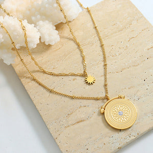 Gold layered necklace with celestial medallion and sun charm