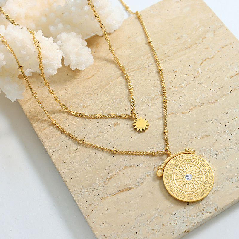 Gold layered necklace with celestial medallion and sun charm