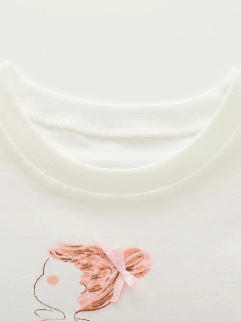White cotton tee with ruffled sleeve detail and a cute graphic of a girl with a pink bow.