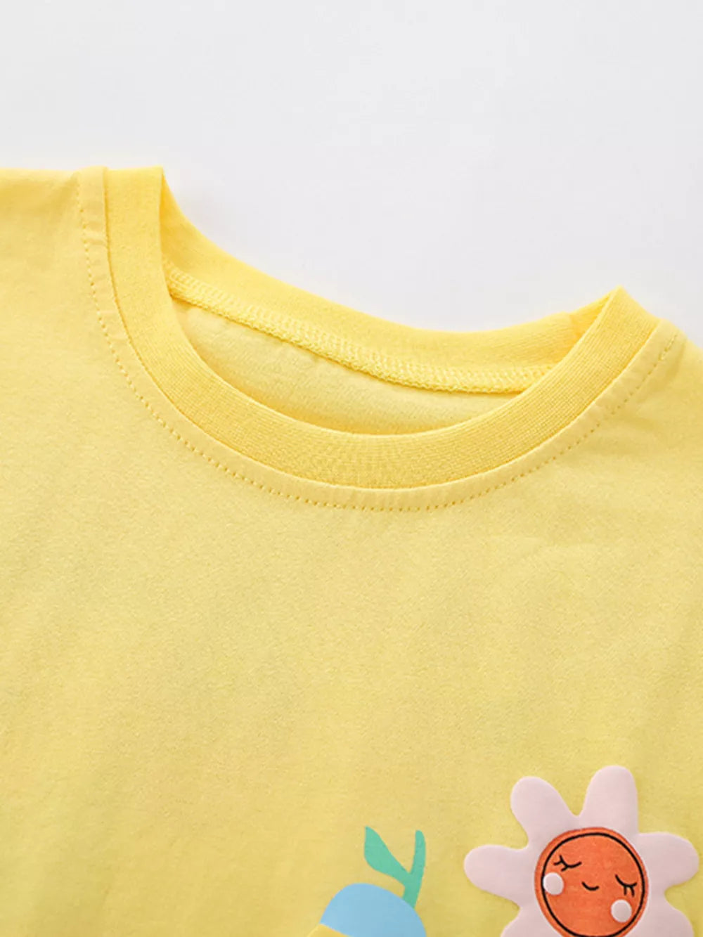 Yellow baby tee with cartoon fruit applique and flower detail