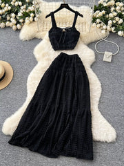 Black ruched crop top and maxi skirt set with tie detail and tiered skirt.