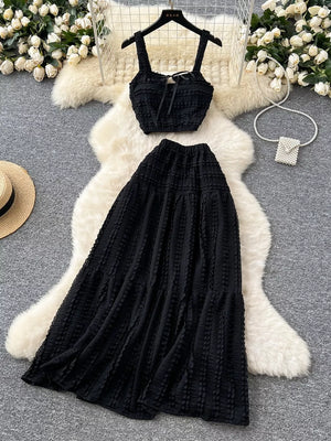 Black ruched crop top and maxi skirt set with tie detail and tiered skirt.