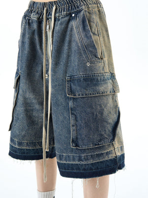 Vintage blue denim cargo shorts with drawstring waist and frayed hem.
