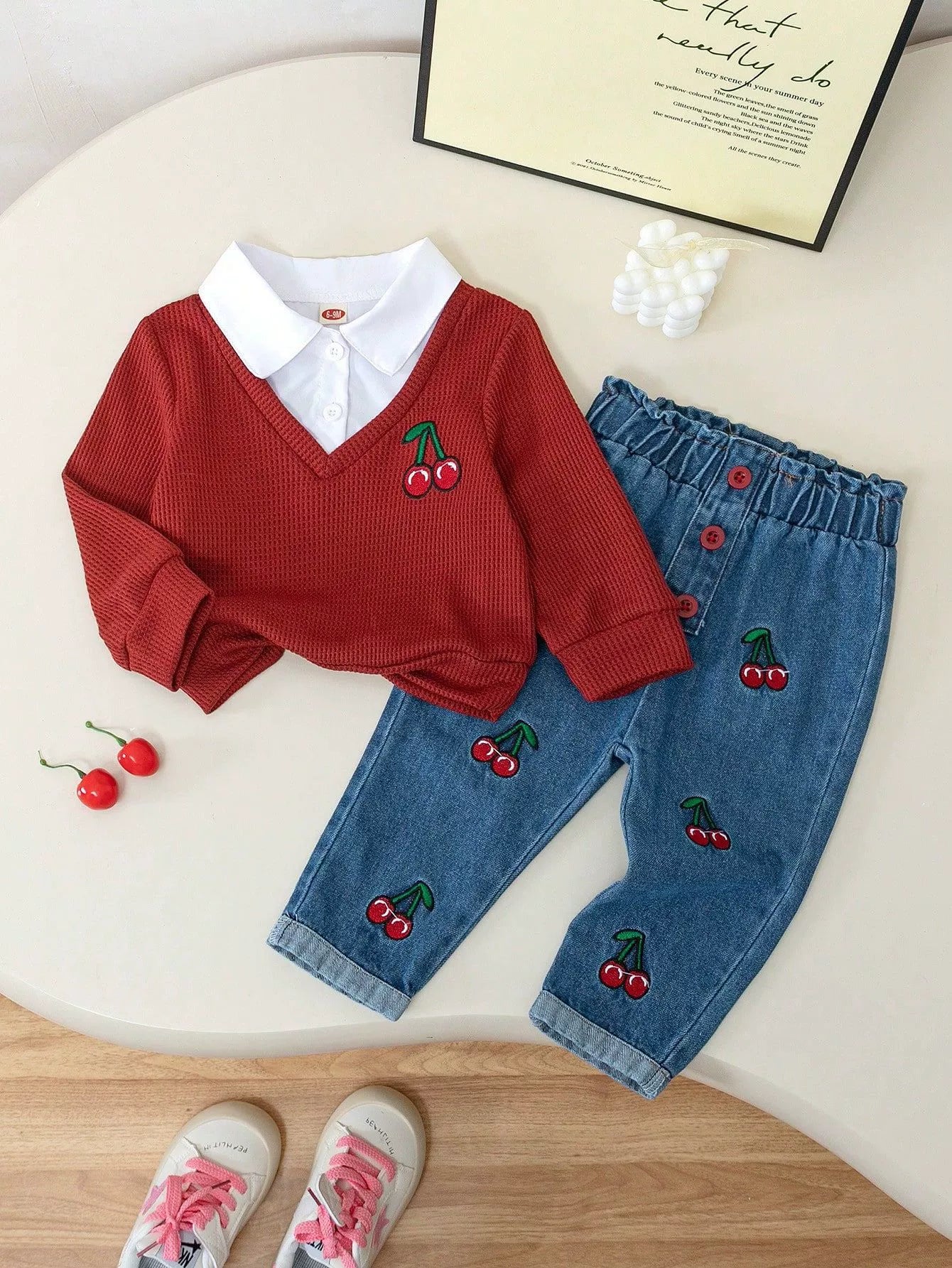 Baby set with red cherry embroidered sweater and jeans.