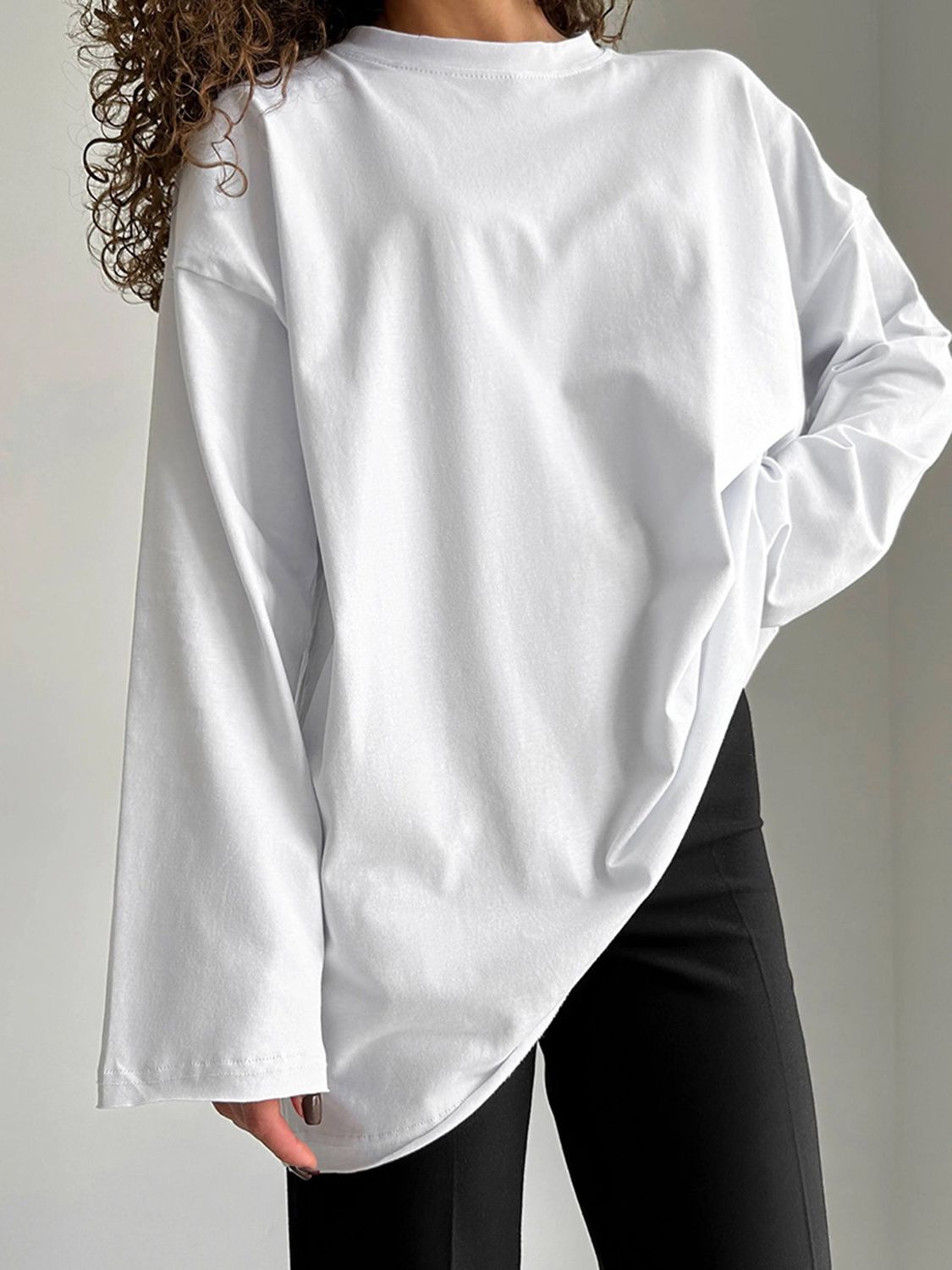 Oversized white cotton jersey long sleeve top with a relaxed fit and crew neck.