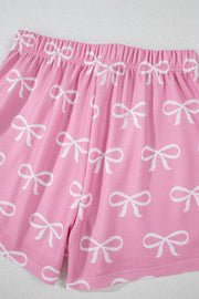 Pink ribbed lounge shorts with allover white bow print and elastic waistband.
