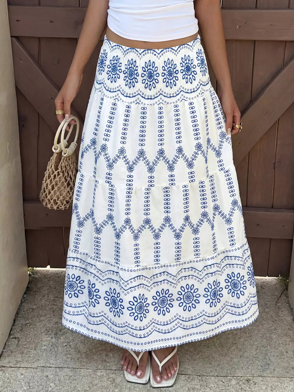 Bohemian maxi skirt with blue floral embroidery and tiered ruffles.