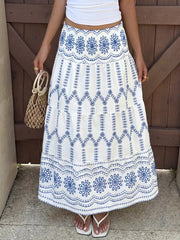 Bohemian maxi skirt with blue floral embroidery and tiered ruffles.